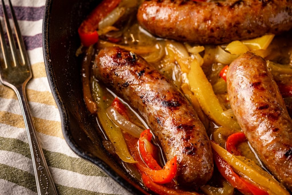 Grilled sausage and peppers in a cast iron skillet.