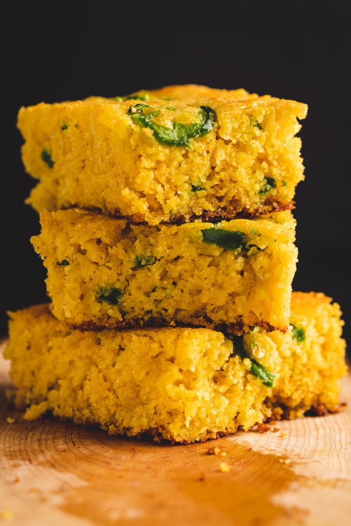 Stack of slices of cheddar jalapeno cornbread on a serving dish.