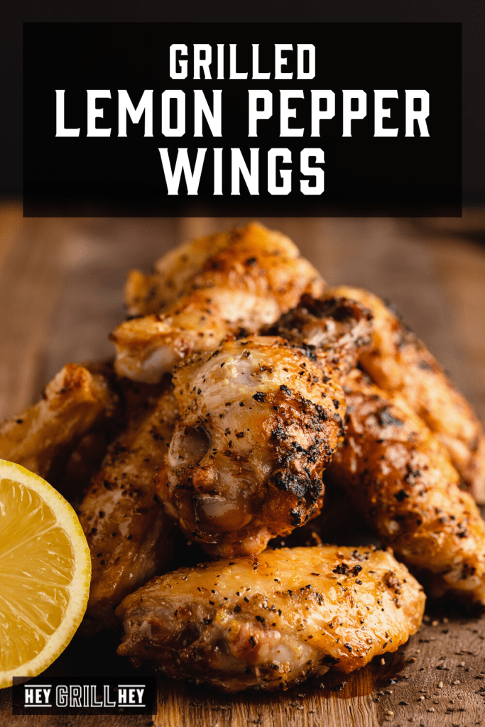 Grilled lemon pepper wings stacked on a wooden cutting board with text overlay - Grilled Lemon Pepper Wings.