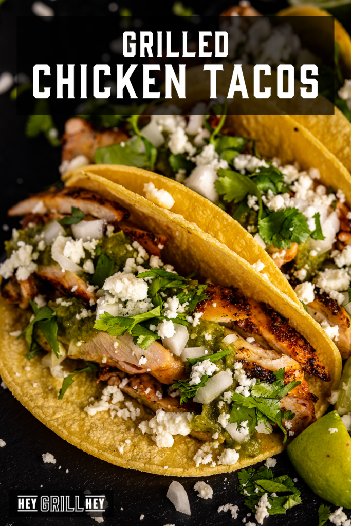 Grilled chicken tacos loaded with cilantro and cheese with text overlay - Grilled Chicken Tacos.