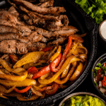 Ingredients for grilled steak fajitas in a cast iron skillet.