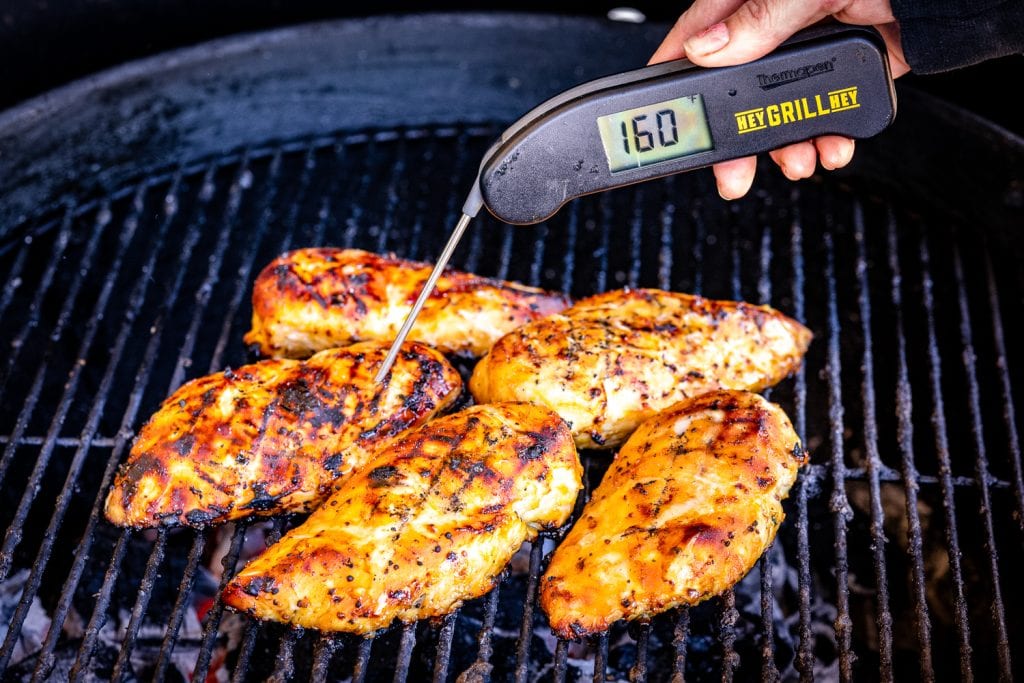 Honey mustard chicken on the grill reading a temperature of 160 degrees F.