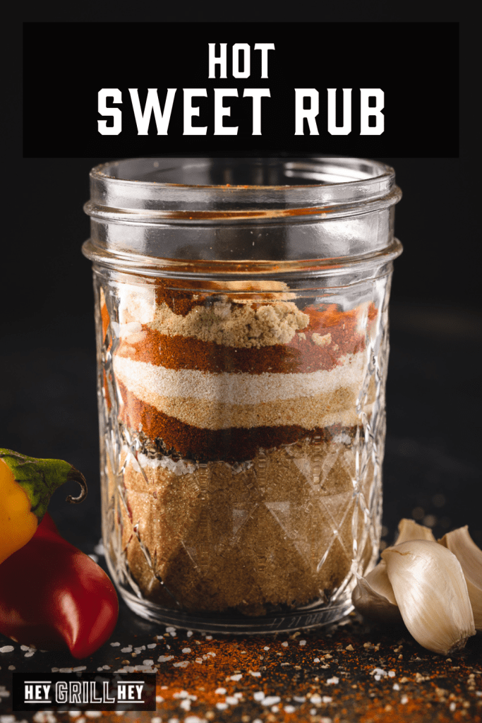 Ingredients for hot sweet rub layered in a glass mason jar with text overlay - Hot Sweet Rub.