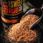 A jar of Spicy Sweet Rub, and a pile of the rub with a metal scoop in it.