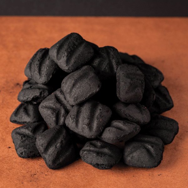 Stack of lump charcoal on butcher paper.