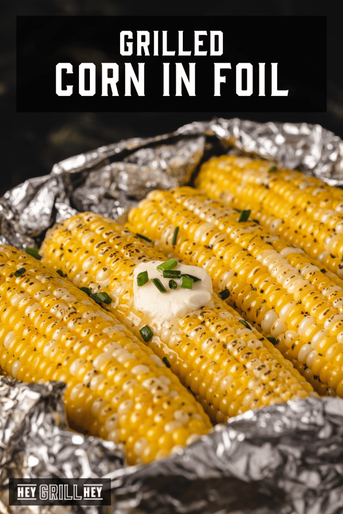 Grilled corn on the cob in a bed of foil with text overlay - Grilled Corn in Foil