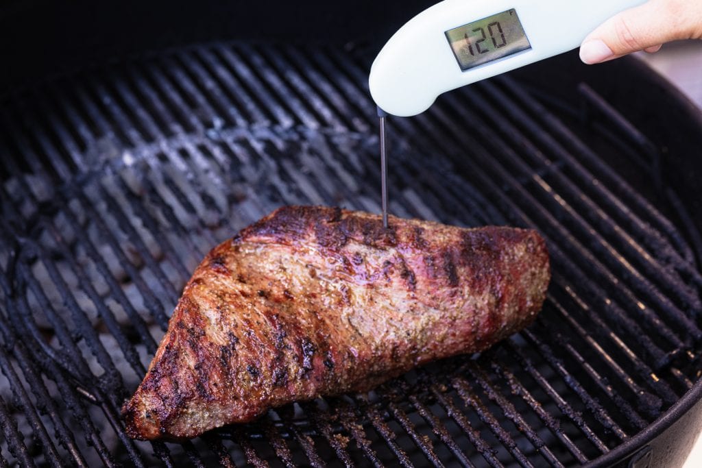 Steak with an instant-read thermometer showing 120 degrees F.