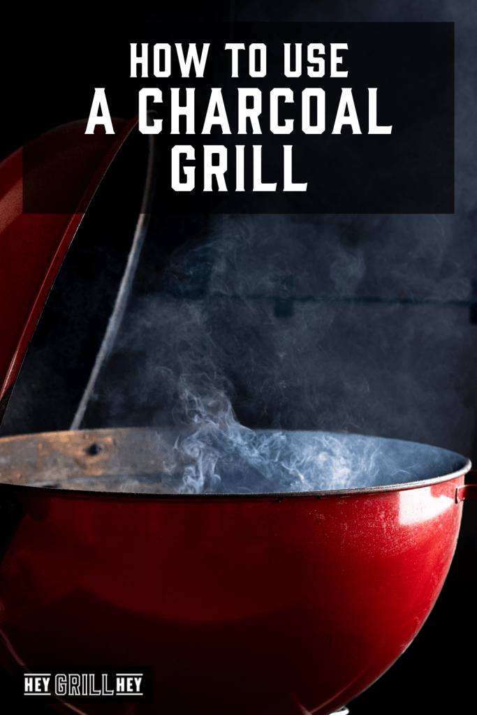 Open charcoal grill with smoke billowing out with text overlay - How to Use a Charcoal Grill.