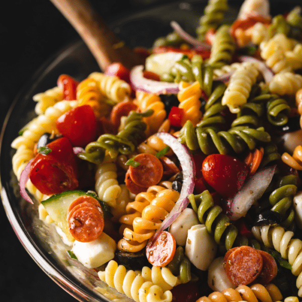 Pasta salad in a glass serving bowl.