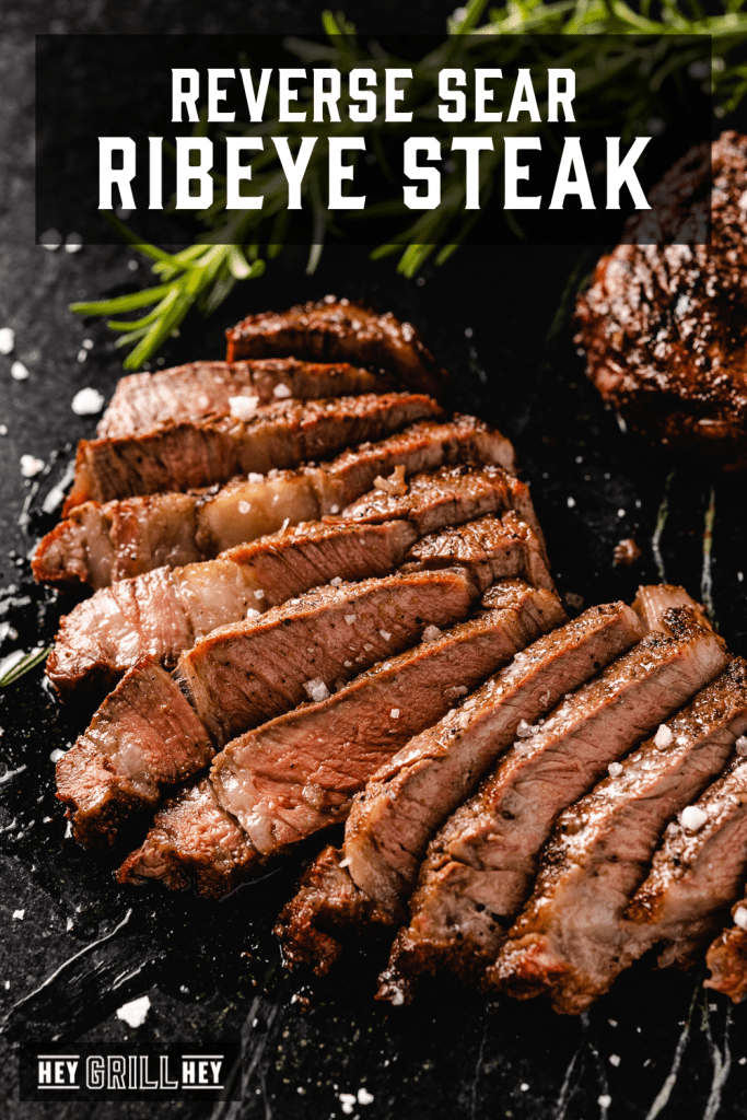 Reverse sear ribeye steak sliced on a serving board with text overlay - Reverse Sear Ribeye Steak.