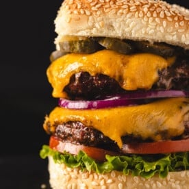 Classic cheeseburger on black background.