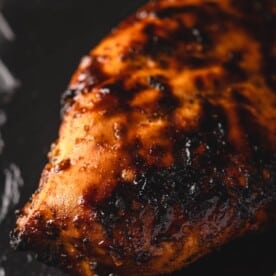 Marinated grilled chicken on black counter.