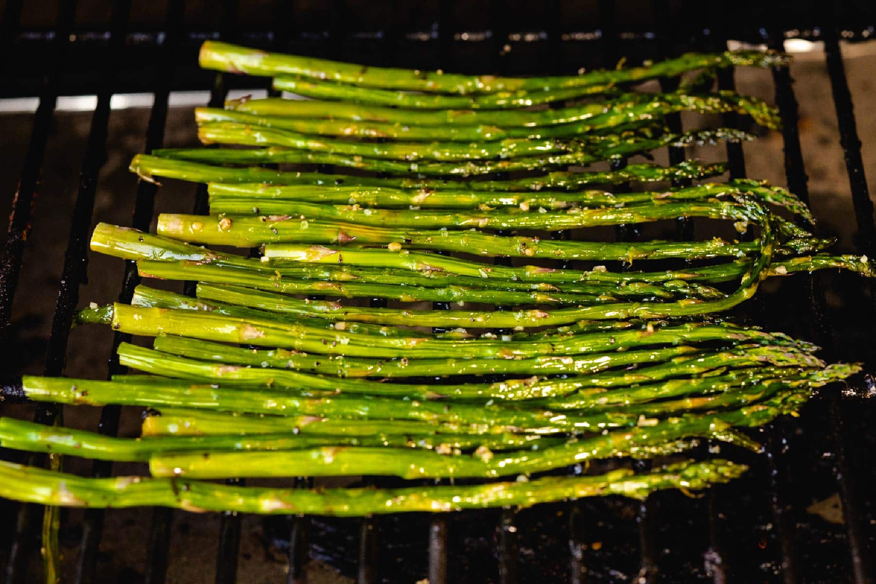 Grilled asparagus on grill grates.