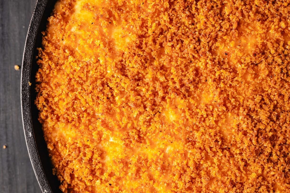 An overhead shot of macaroni in a skillet topped with bread crumbs.