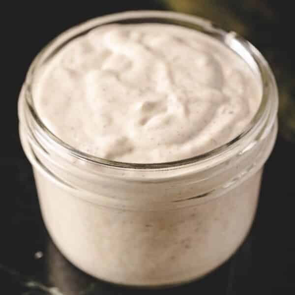 Creamy horseradish sauce in glass jar.