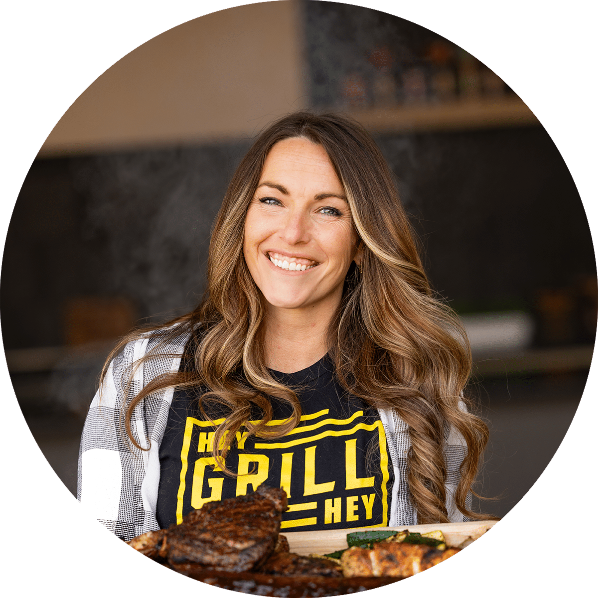 A profile picture of Hey Grill Hey found Susie Bulloch holding a platter filled with BBQ meats.