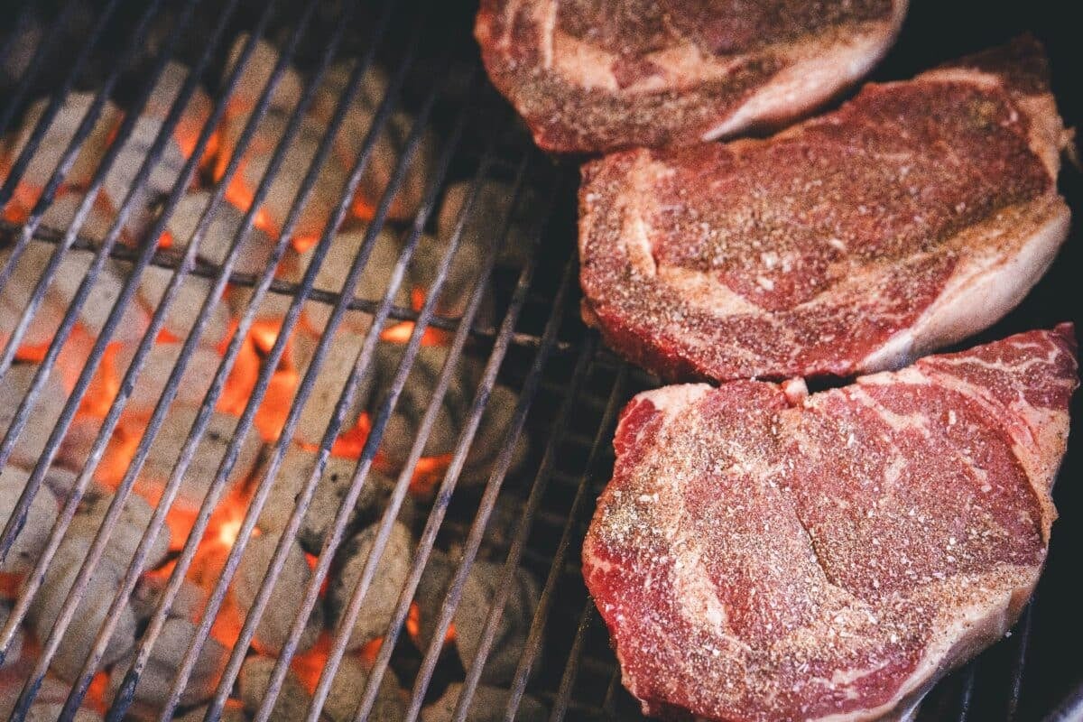 Seasoned steaks over indirect heat.