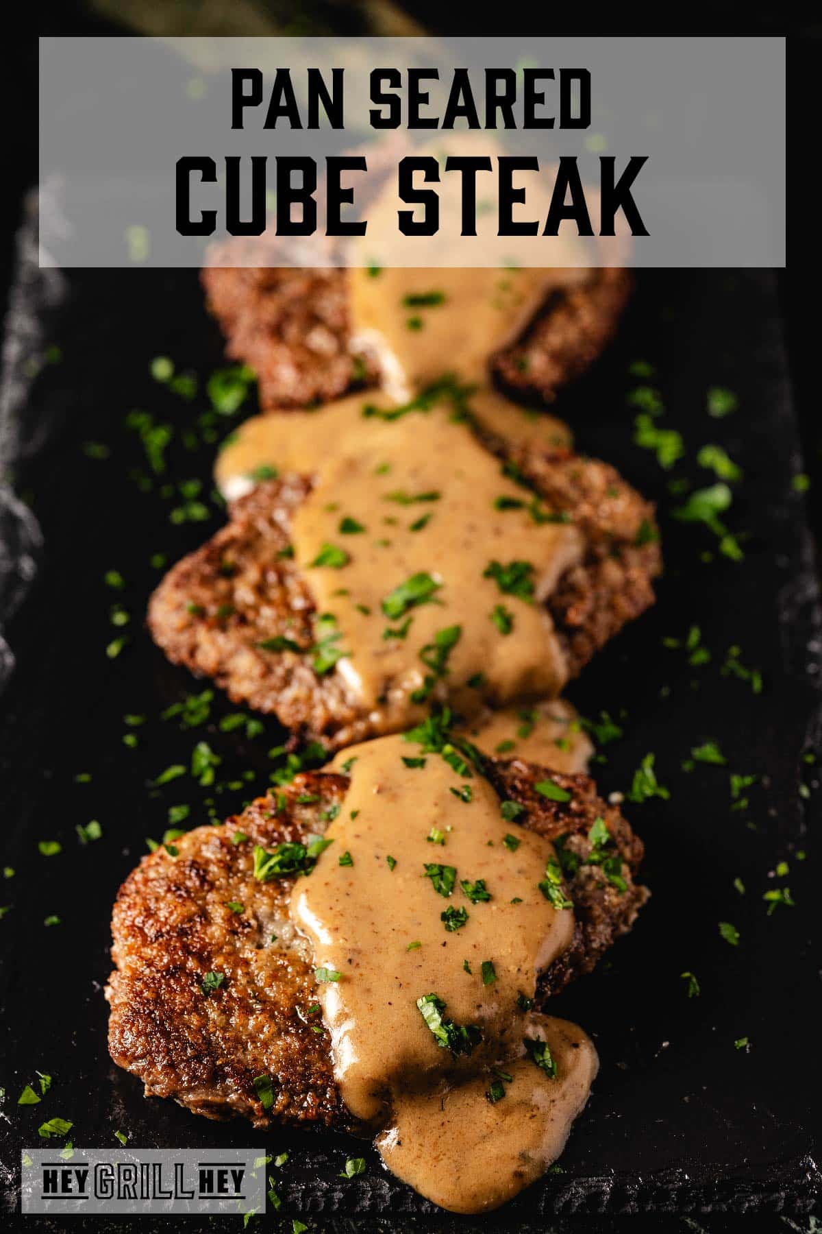 Cube steaks coated in gravy on serving platter. Text reads "Pan Seared Cube Steak".