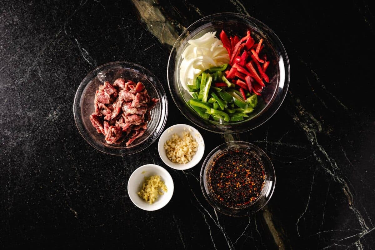 Steak seasoning ingredients in glass bowls on countertop.