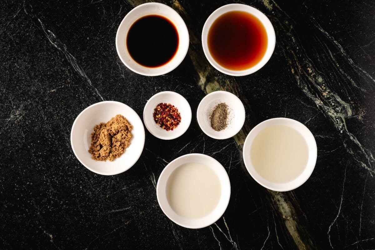 Sauce ingredients in white bowls on countertop.