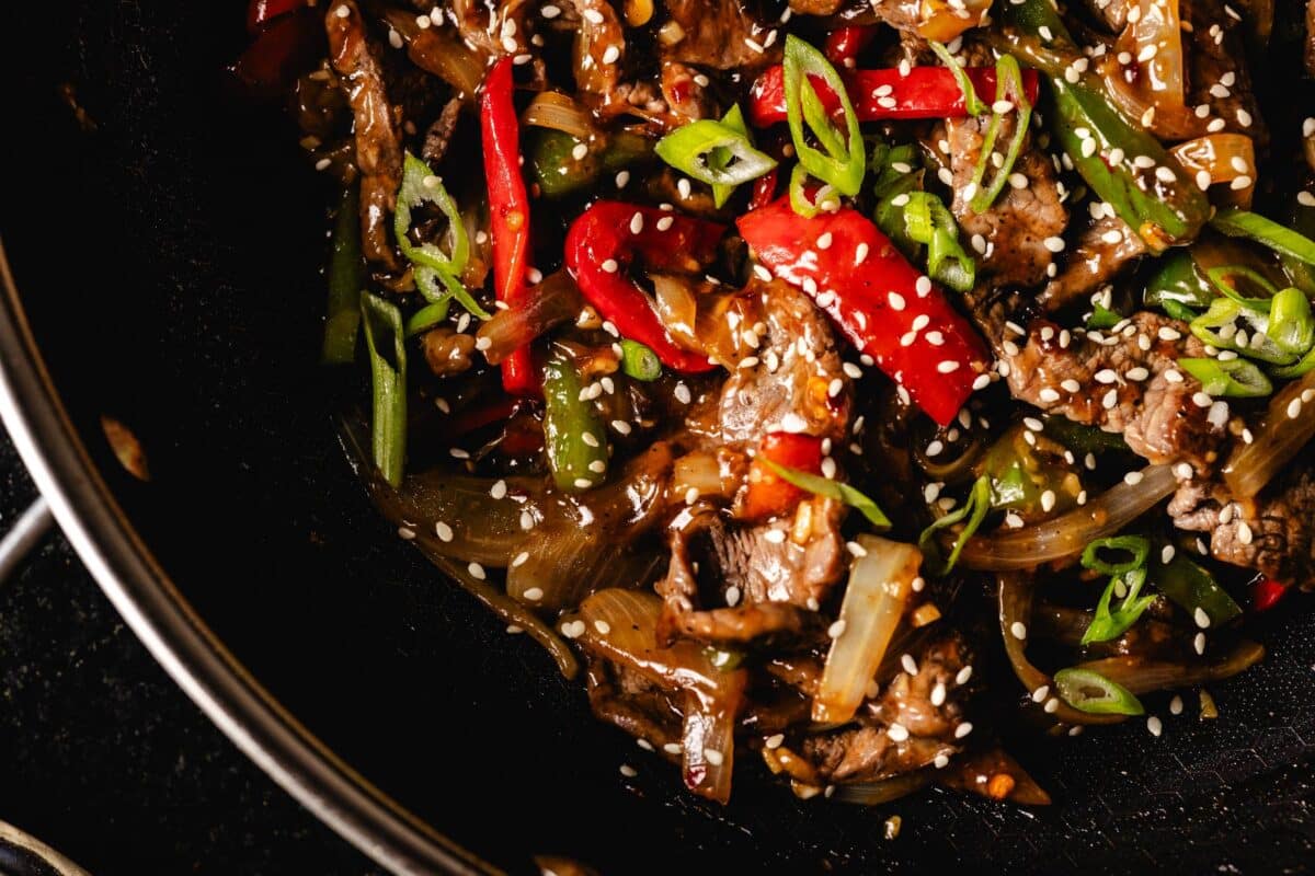 Steak and peppers in wok.