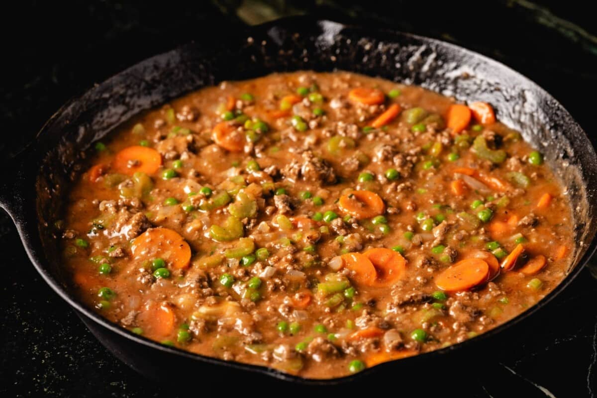 Braised lamb and vegetable filling in skillet.