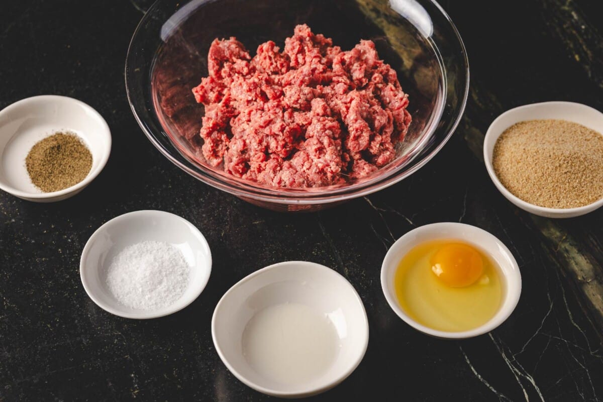 Ground beef in and seasoning ingredients in glass bowls.