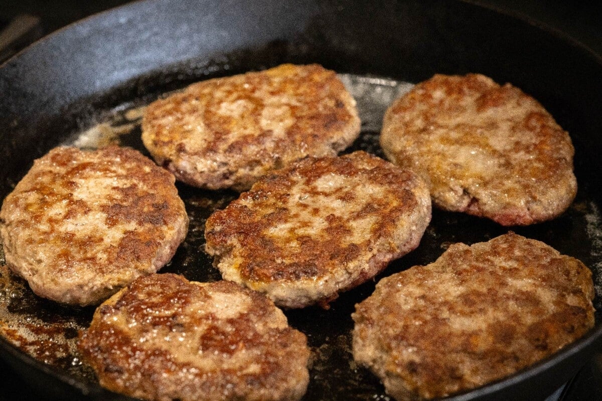 Salisbury steak patties in cast iron skillet.