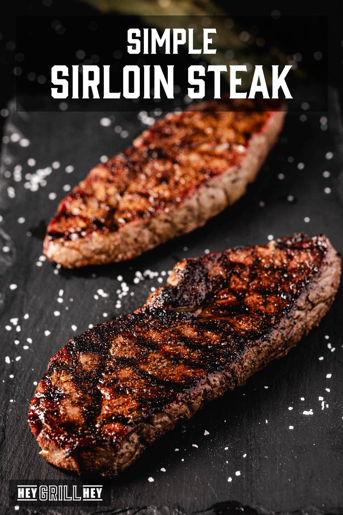 Sirloin steaks on black serving platter sprinkled with salt. Text reads "Simple Sirloin Steak".
