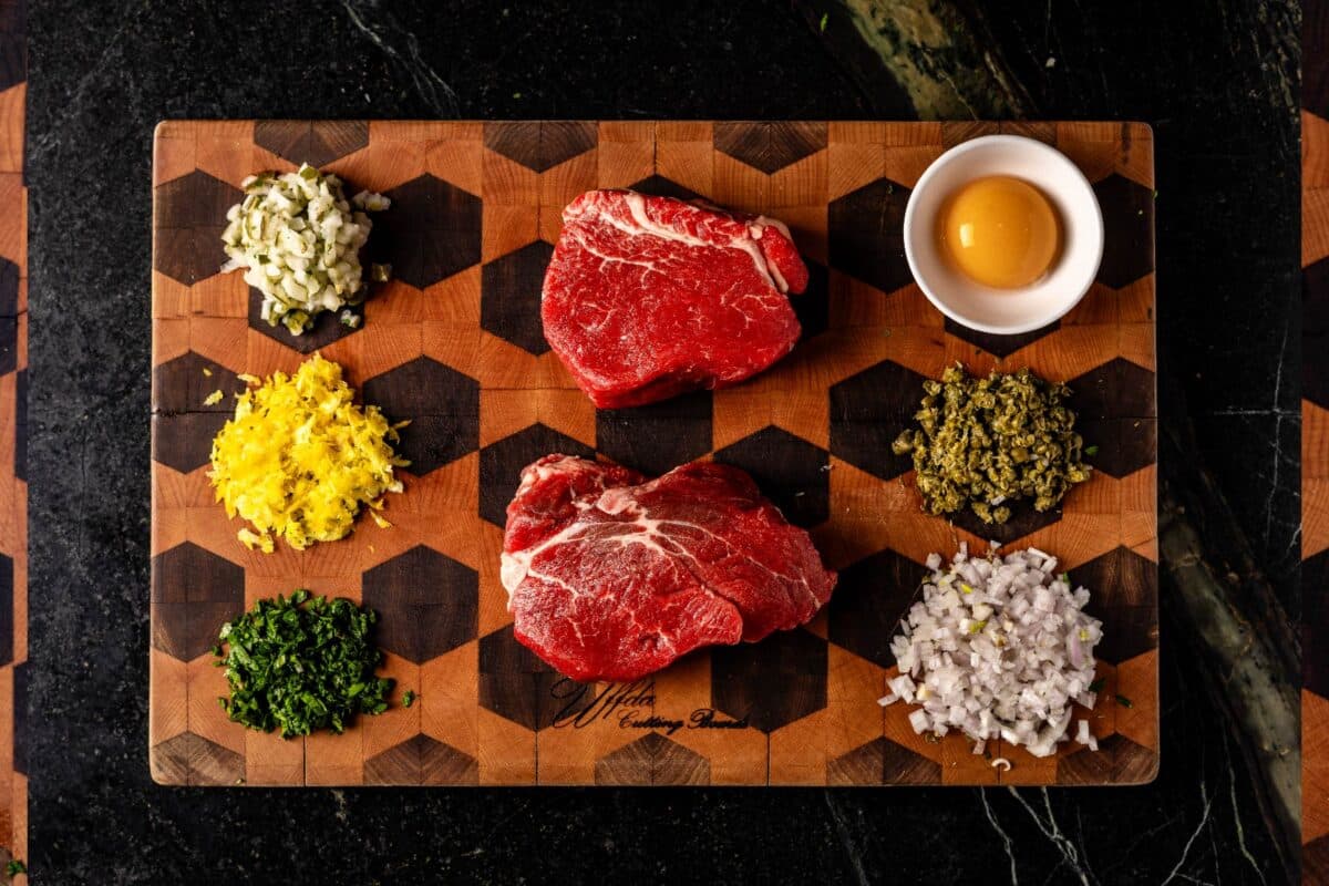 Raw filets and other ingredients on cutting board.