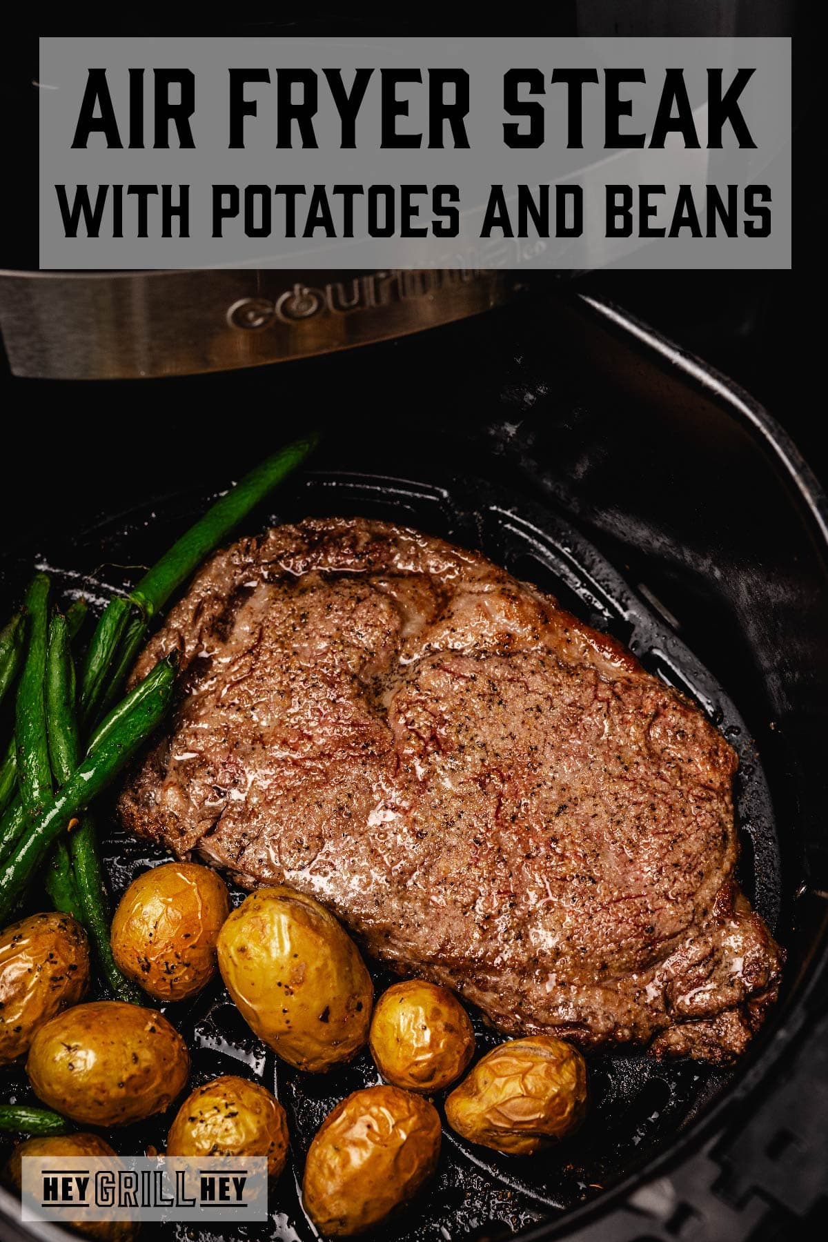 Steak, potatoes, and green beans in air fryer tray. Text reads "Air Fryer Steak with Potatoes and Beans".
