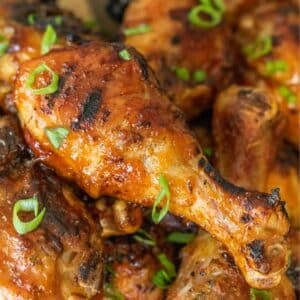Grilled chicken drumstick with green onion slices.