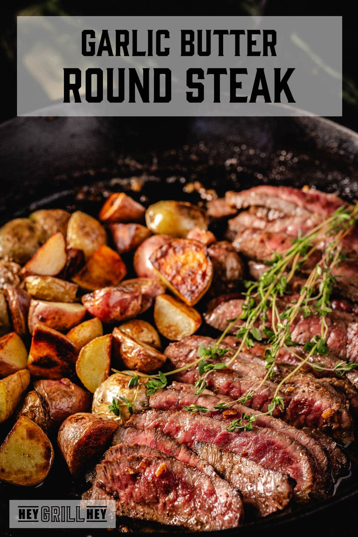 Sliced steak in skillet with potatoes. Text reads "Garlic Butter Round Steak".