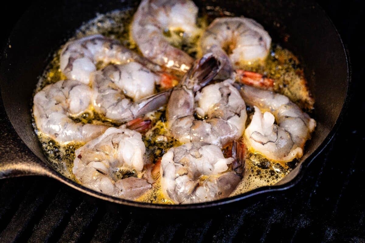 Shrimp in garlic butter in cast iron skillet.