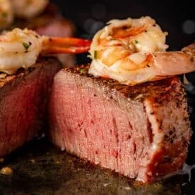 Sliced steak tops with garlic shrimp.