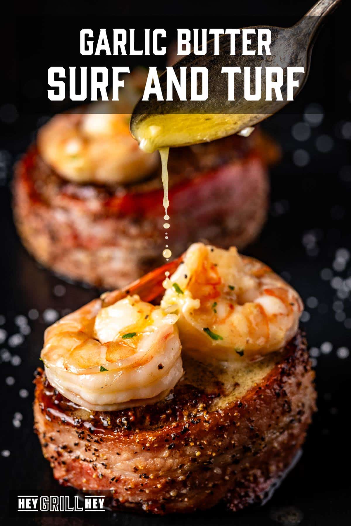 Bacon wrapped filets topped with shrimp and drizzled with garlic butter. Text reads "Garlic Butter Surf and Turf".