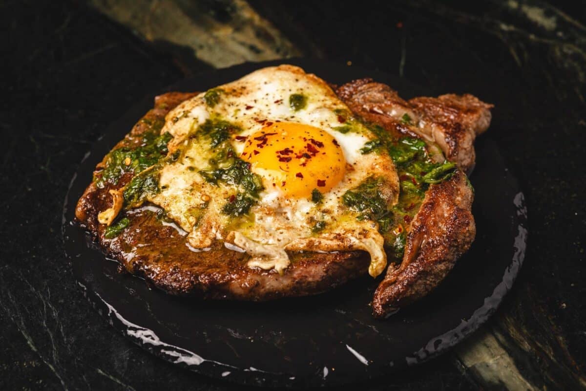 Steak topped with fried eggs and chimichurri.