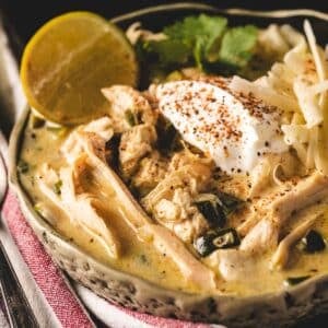 White chicken chili in bowl topped with sour cream.