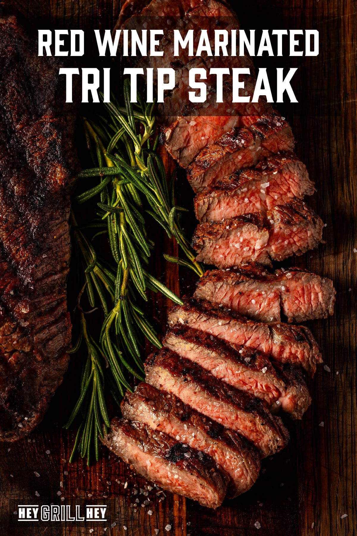 Sliced steak on serving platter with garnish. Text reads "Red Wine Marinated Tri Tip Steak".