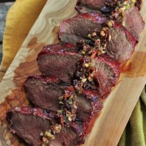 Grilled venison steak slices on serving platter.