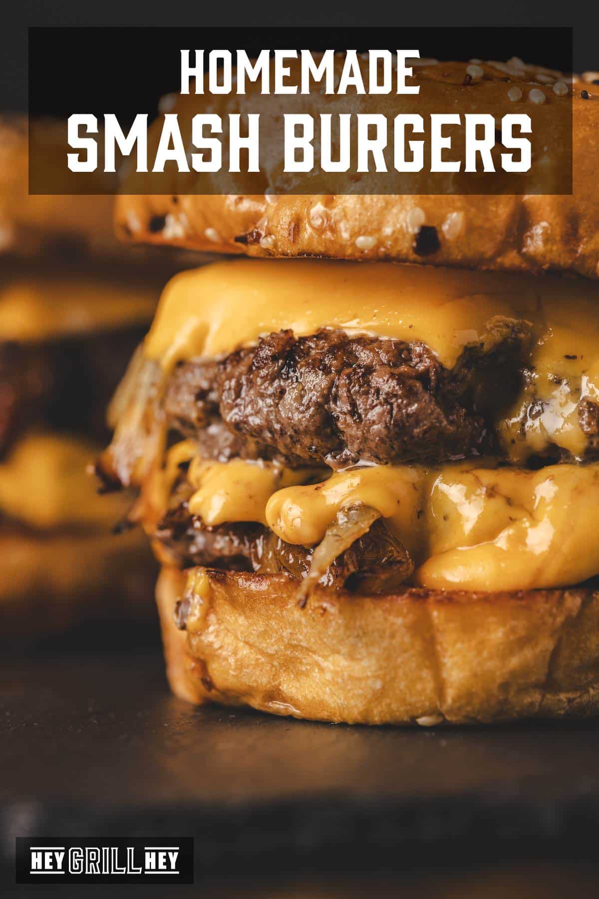 Grilled cheeseburgers with sesame buns on black surface. Text reads "Homemade Smash Burgers".