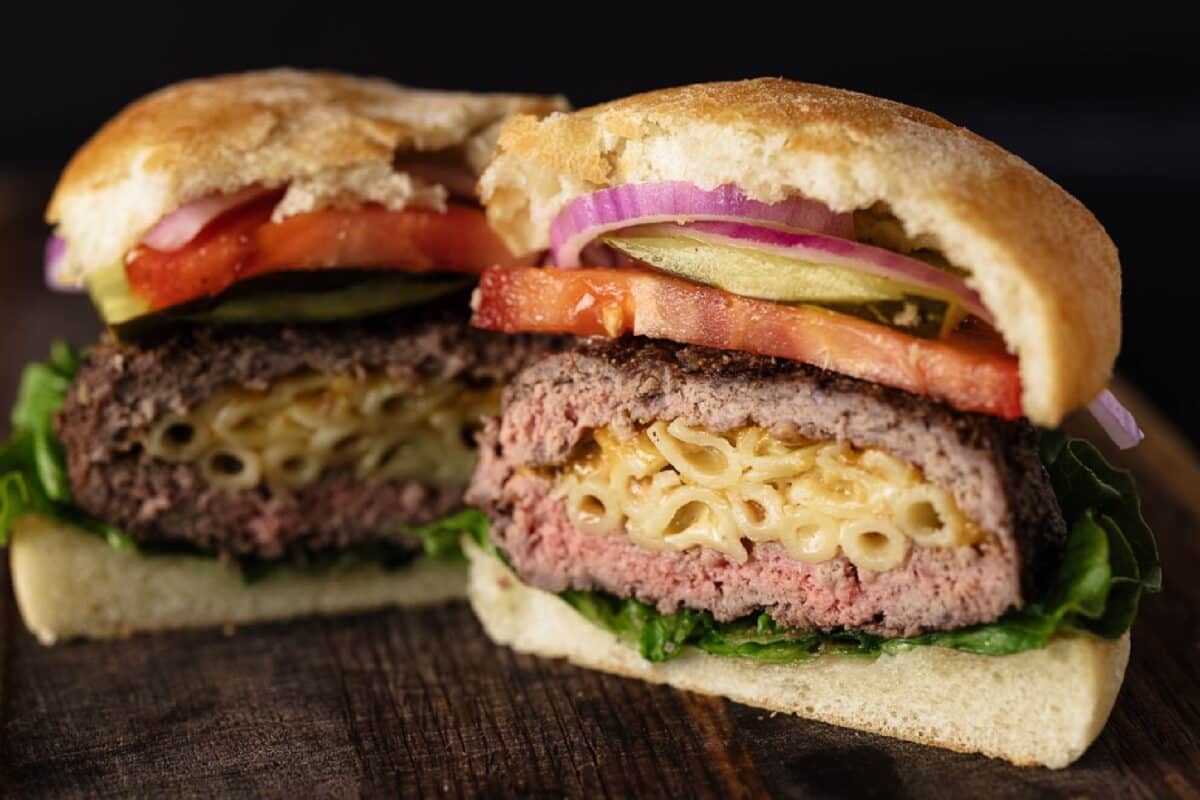 Burger sliced in half with a mac and cheese stuffed patty.