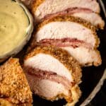 Chicken Cordon Bleu slices next to bowl of Dijon mustard sauce.