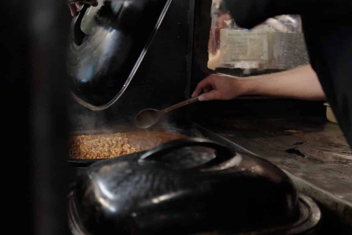 Pinto beans in pot being stirred.