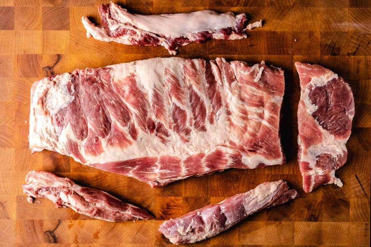 A trimmed rack of ribs on a wooden cutting board.