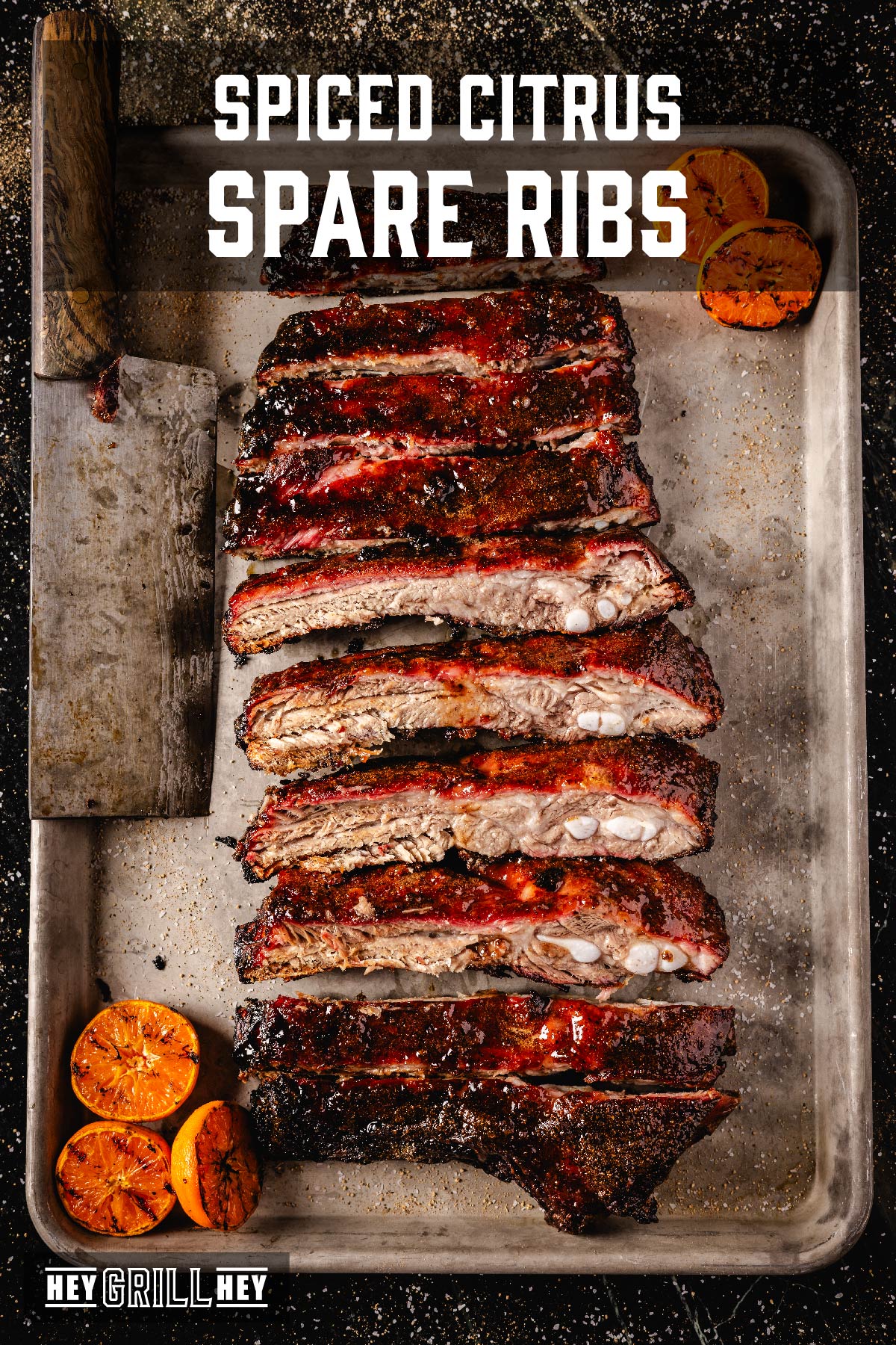 Sliced spare ribs on serving platter next to smoked citrus halves. Text reads "Spiced Citrus Spare Ribs."