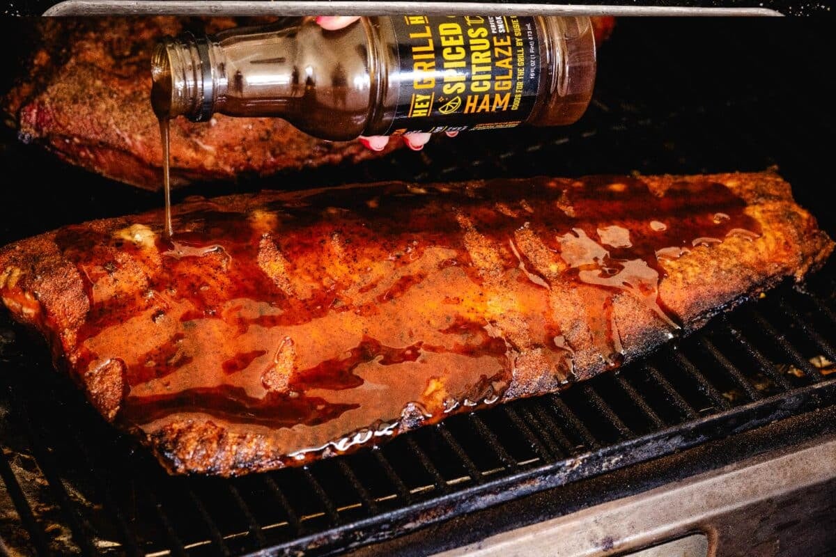 Salmon on the smoker being glazed with Spiced Citrus glaze.