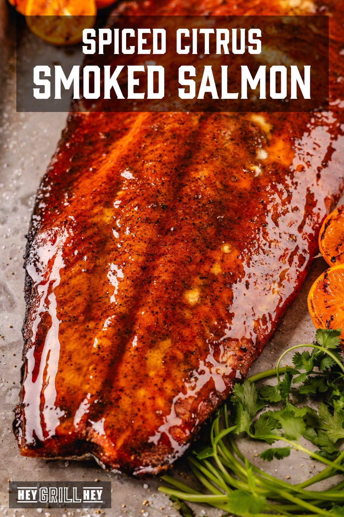 Smoked and glazed salmon on platter with cilantro leaves. Text reads "Spiced Citrus Smoked Salmon".