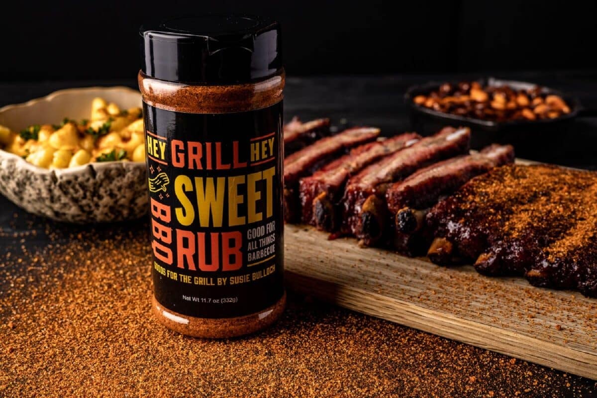 Bottle of Seasoning in front of cutting board with sliced ribs.