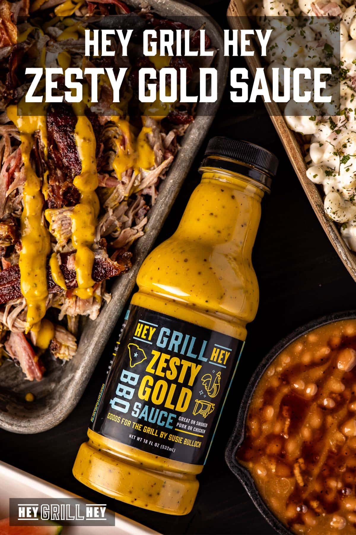 Bottle of mustard sauce next to platter of pulled pork, bowl of beans, and tray of potato salad. Text reads "Hey Grill Hey Zest Gold BBQ Sauce".